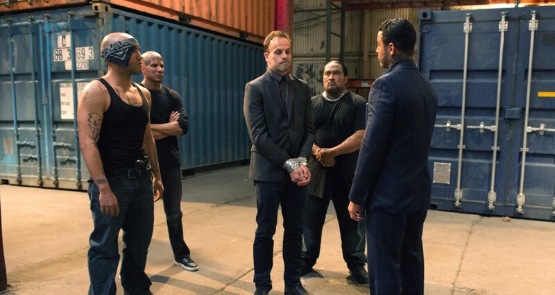 Sherlock (Jonny Lee Miller, M.) wird von El Halcoln (Jon Huertas, r.) und seiner gefährlichen Drogendealer-Bande gekidnapped und gezwungen herauszufinden, wer Smuggler Torres getötet hat. In der Hoffnung durch die Bande einen Heroin-Dealer ausfindig machen zu können, nimmt er sich dem Fall an. Ein Fehler? – Bild: CBS Broadcasting, Inc.