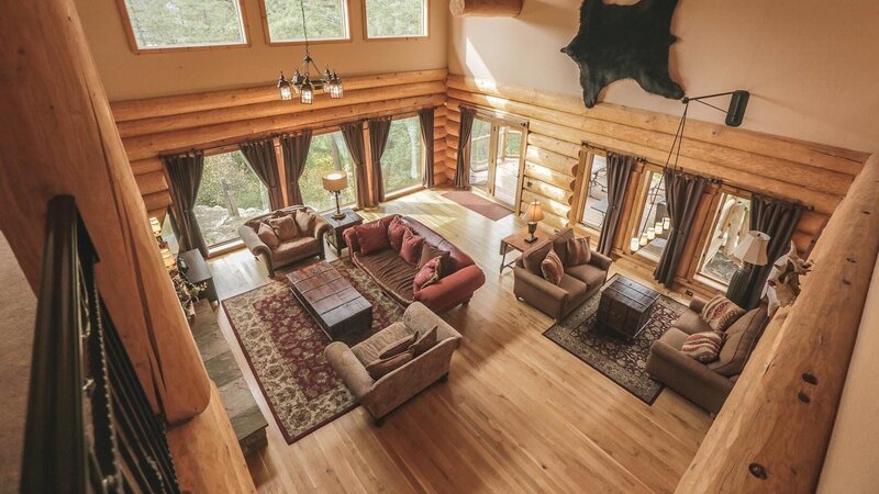 Looking down to the living room of the Silver Spruce Lodge from the second floor shows off the open space and high windows, as seen on Log Cabin Living. – Bild: HGTV/​Scripps Networks, LLC.