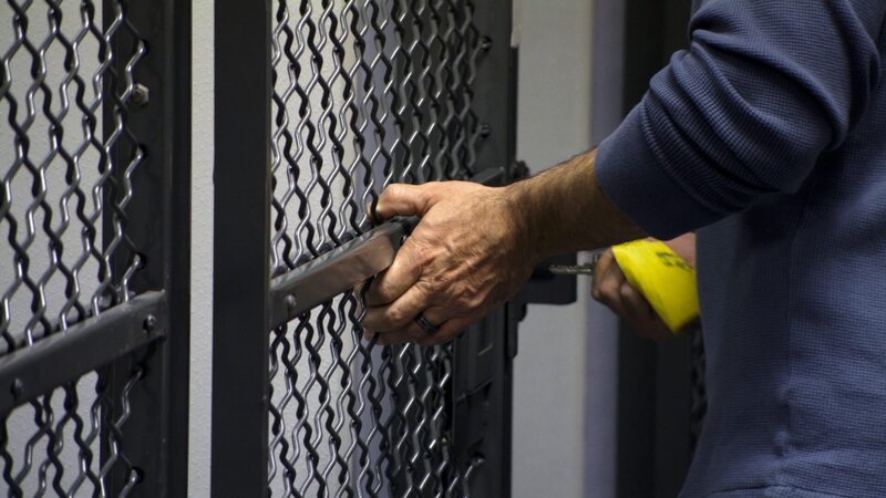 HSI Special Agent Marino locks the door to a temporary cell holding a traveler whose bag contained nearly four kilograms of cocaine. – Bild: National Geographic Television
