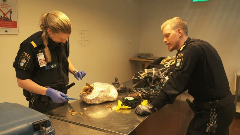 Die Grenzbeamten überprüfen den Inhalt des Pakets. – Bild: Discovery