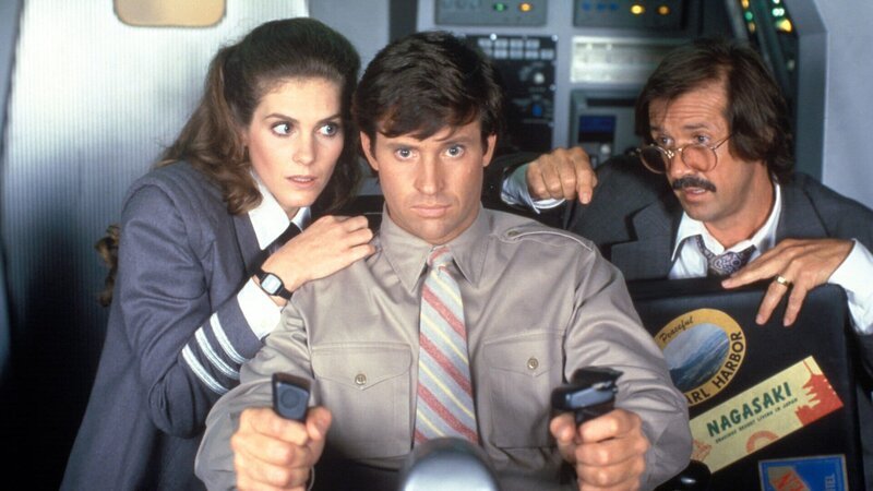 Flugingenieurin Elaine Dickinson (Julie Hagerty, l.), Ted Striker (Robert Hays, M.) und der Passagier Joe Seluchi (Sonny Bono, r.) versuchen, das Raumschiff zu lenken und den Flug unter Kontrolle zu bringen. – Bild: ZDF Flugingenieurin Elaine Dickinson (Julie Hagerty, l.), Ted Striker (Robert Hays, M.) und der Passagier Joe Seluchi (Sonny Bono, r.) versuchen, das Raumschiff zu lenken und den Flug unter Kontrolle zu bringen. – Bild: ZDF