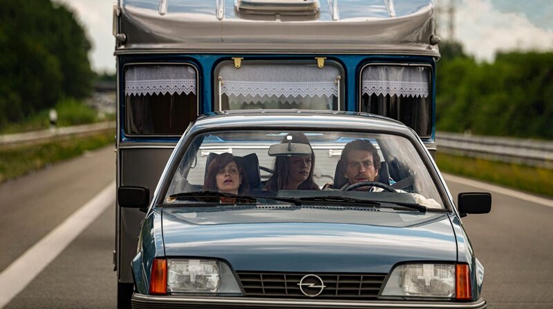 Anna Thalbach, Elisabeth Denz und Enrique Fiß (v. l. n. r.) als Familie Schröder auf dem Weg in den Campingurlaub. – Bild: NDR/​jumpmedientv GmbH/​Hardy Brackmann