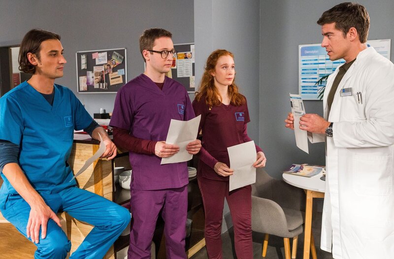 Ivo Maric (Jakob D’Aprile, l.), Oliver Probst (Arne Kertész, 2.v.l.) und Tamar Hummel (Linda Kummer, 3.v.l.) präsentieren Ben Ahlbeck (Philipp Danne, r.) ihre Ergebnisse der Bluttests. – Bild: ARD/​Tom Fülle