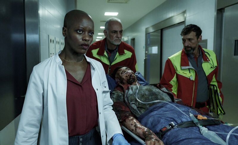 Dr. Jamila Jost (Florence Kasumba) hat eine schreckliche Ahnung, als der völlig verbrannte Damir Vucovic (Aaron Kissiov) sie bei seiner Einlieferung in die Notaufnahme in einer mysteriösen Sprache bedroht. – Bild: Roland Guido Marx /​ ZDF