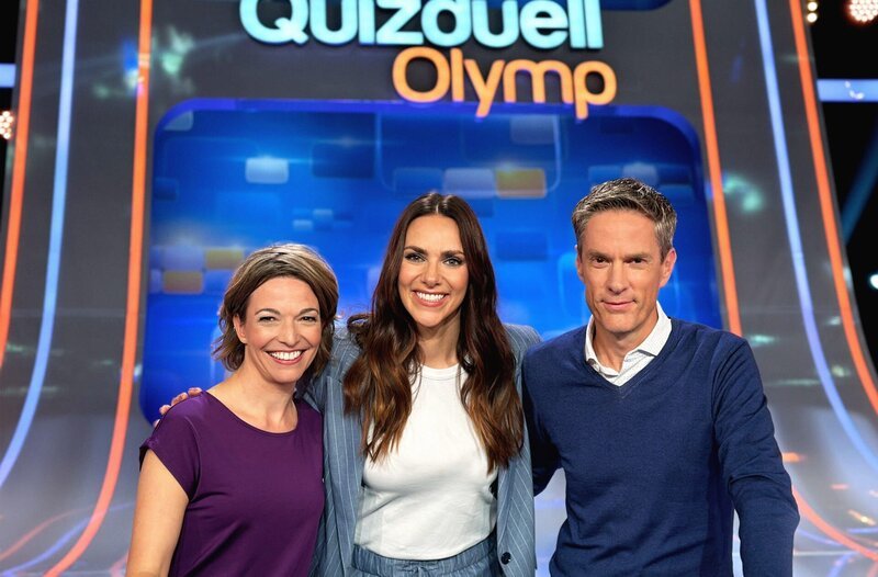 Moderatorin Esther Sedlaczek (M.) mit den Kandidaten des Teams „MOMA“: Anna Planken (l.) und Sven Lorig (r.). – Bild: ARD/​ITV Studios