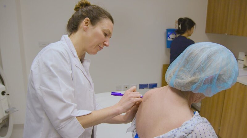 Shot of Dr Emma marking up Josée for her surgery. – Bild: Warner Bros. Discovery, Inc.