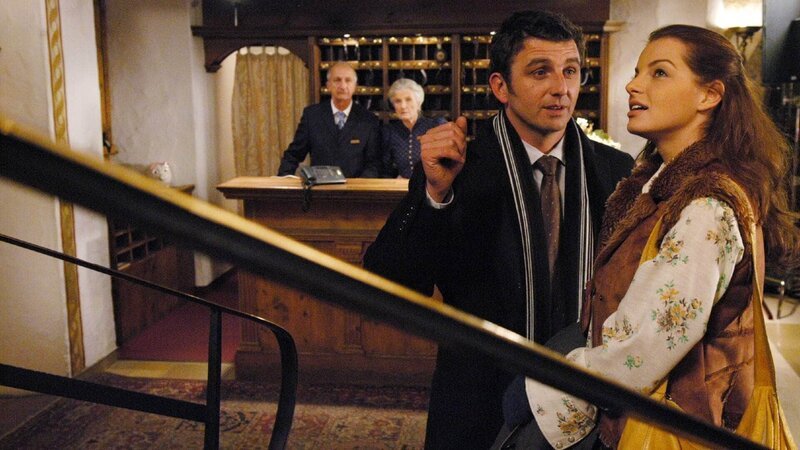 Hans und Elisabeth Mäurer (hi. Philipp Sonntag, Luise Deschauer) beobachten Hotelier Maximilian (Hans Sigl) und die angereiste Marla Hofer (Yvonne Catterfeld) mit Argwohn. Die junge Frau soll für ein Münchner Reisebüro eine Pauschalreise an den Königssee ausarbeiten. – Bild: RTL