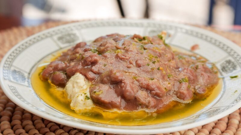 Geschmorte Favabohnen oder Ful sind die Krönung eines Tellers mit dem berühmten Hummus im Jerusalemer „Ikermawi“. – Bild: ORF/​Warner/​The Travel Channel