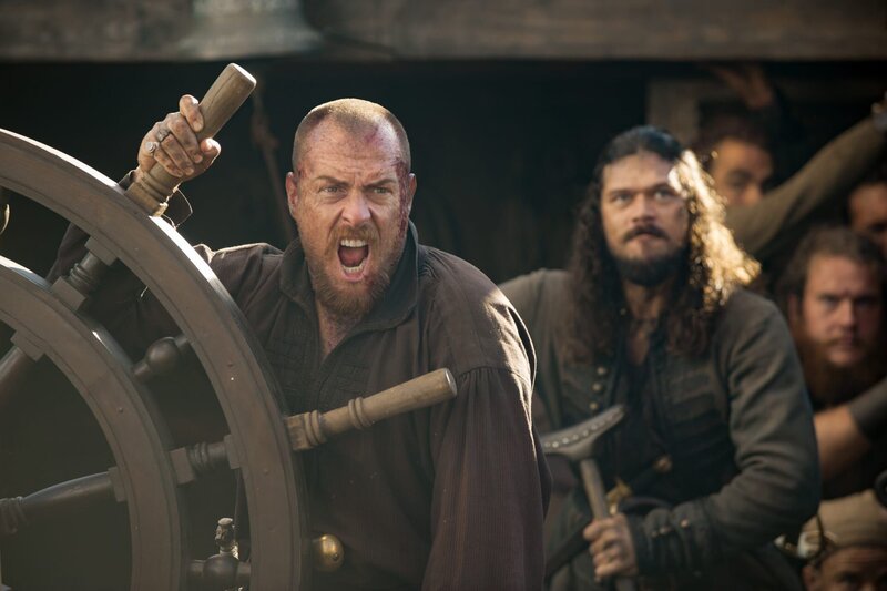 Flint (Toby Stephens, l.) und Silver (Luke Arnold, r.) streiten über den Schatz, während die Piraterie offiziell verboten wird. – Bild: Starz Entertainment, LLC