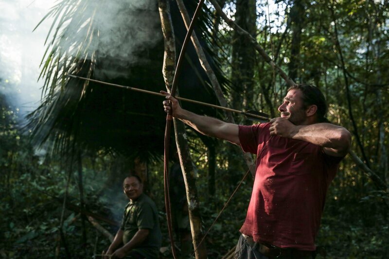 Die Ältesten von Wai Wai, Charakura, (Hintergrund) und Hazen (Vordergrund) schießen Pfeile. – Bild: National Geographic/​Tess Benjamin