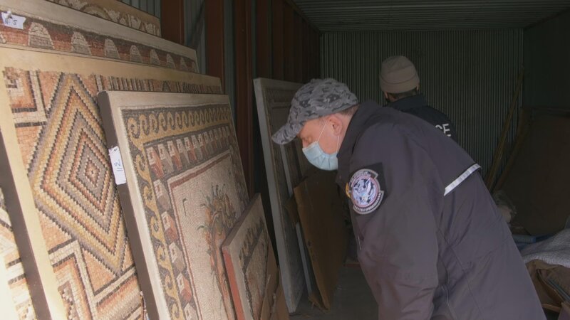 CBP-Beamter Acevedo und HSI-Agent Robert inspizieren ein in einem Lagerraum gefundenes Mosaikversteck. – Bild: National Geographic