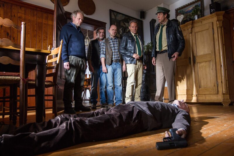 Unerlaubtes Glückspiel im Landgasthof Reitbacher? Als Hubert und Staller dem Verdacht nachgehen, erweist sich die vermeintliche Pokerrunde als harmlos. Doch plötzlich ertönt aus dem Nebenraum ein Schuss – Josef Brunner, Miteigentümer des Brunnerhofs, hatte offenbar kurz vor Eintreffen der Polizei den Spieltisch verlassen und sich das Leben genommen. V.l.n.r. Gerd Brunner, Sepp Reitbacher, Alois Brunner, Hubert und Staller, Leiche. – Bild: ARD/​TMG/​Chris Hirschhäuser