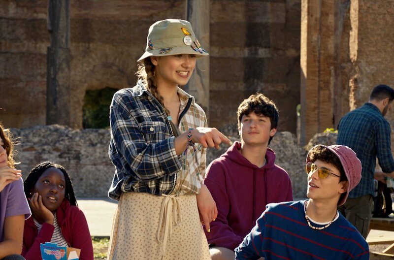 Lucy (Kensington Tallman, 3.v.l.) steht vor ihrer Klasse in einer Ausgrabungsstätte in Rom. – Bild: SWR/​HR/​Red Monk Studios srl/​HSR S1 (FGM) Inc.