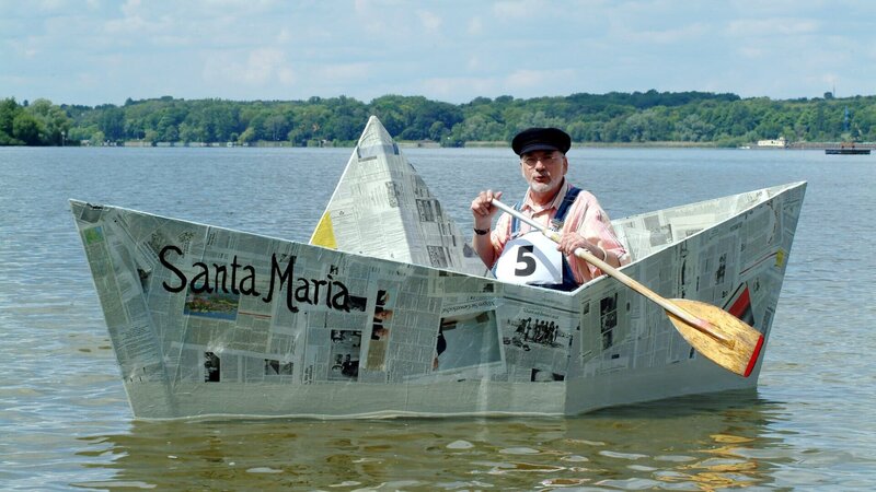 Peter (Peter Lustig) nimmt mit seinem Papierboot „Santa Maria“ an der Bärstädter Papierbootregatta teil. – Bild: ZDF und Christiane Pausch