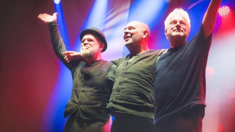 Werner Schmidbauer (rechts) und Martin Kälberer (links) freuen sich bei ihrem Auftritt auf dem Münchner Tollwood-Festival über den Besuch des niederbayerischen Musikers, Kabarettisten und Moderators Hannes Ringlstetter. – Bild: Michael Praetorius
