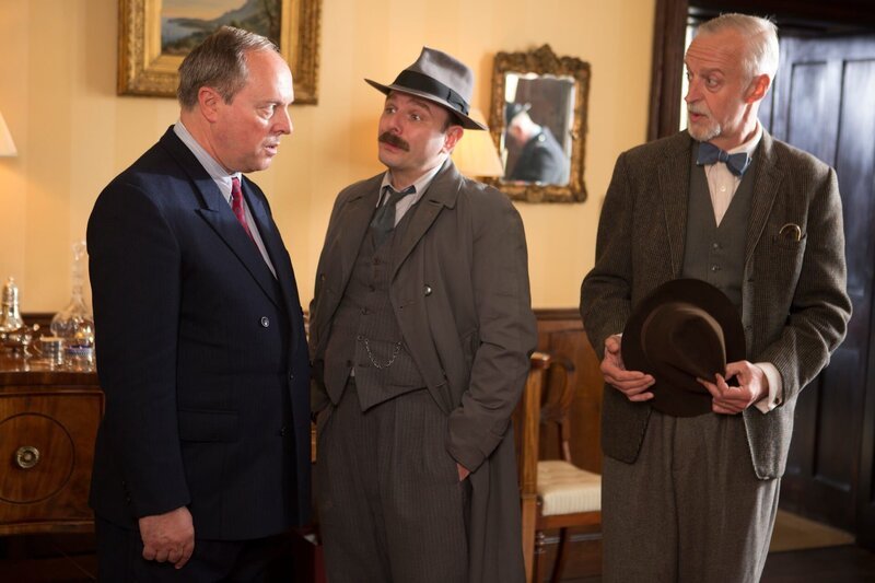Inspector Mallory (Jack Deam, M.) befragt Robert Twyman (Robert Daws, l.), den Vater des Toten. Beide können sich nicht erklären, wie sich der Mörder Zugang zu dem Haus verschaffen konnte. Der Psychoanalytiker Mordaunt Jackson (Paul Bown, r.) kommt hinzu. – Bild: ZDFneo