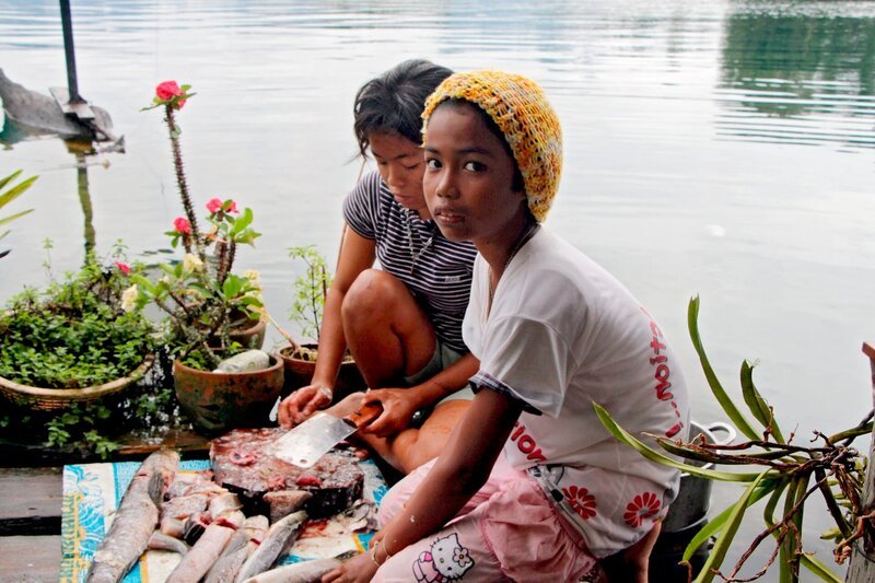 Die Töchter der Fischerfamilien am thailändischen Khao-Sok-See nehmen den Fang aus. – Bild: NDR/​Eikon Media/​Enrico Demurray