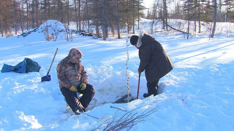 Charlie Wright (L) takes a break while his son, Bob Wright (R), chips through the ice to get a beaver trap. – Bild: Discovery Communications