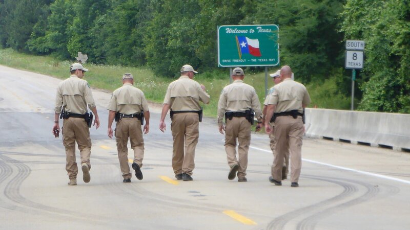 Wardens walk the country road past the „Welcome to Texas“ sign. – Bild: Discovery Networks
