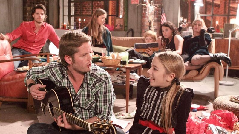 Weihnachten in der WG: Ingo (André Dietz, vo.li.) hat von Zoé (Carolin von der Groeben, vo.re.) eine Gitarre geschenkt bekommen. Jetzt singen sie gemeinsam Weihnachtslieder, während die Mitbewohner (hi.v.li.: Stephen Dürr, Nathalie Thiede, Tanja Szewczenko, Ulrike Röseberg, Juliette Menke) die Stimmung genießen. – Bild: TVNOW /​ Frank Hempel