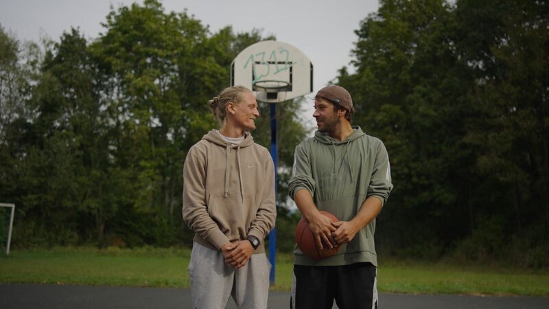 Von links: Andreas Reich und Simon Limpert, zwei Freunde aus Baunach bei Bamberg, die mit dem Fahrrad von Bamberg nach Bangkok gefahren sind, auf dem Basketballplatz in Baunach bei Bamberg. – Bild: Schelke Bonnetsmüller /​ BR, south & browse GmbH