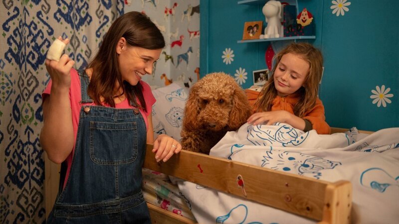 Tess (Andrea Valls, l.) sagt Wuffel und Evi (Tahliya Lowles, r.) gute Nacht. Sie hat sich beim Herumtollen mit den Hunden zwei Finger verstaucht. – Bild: ZDF/​Darrall MacQueen