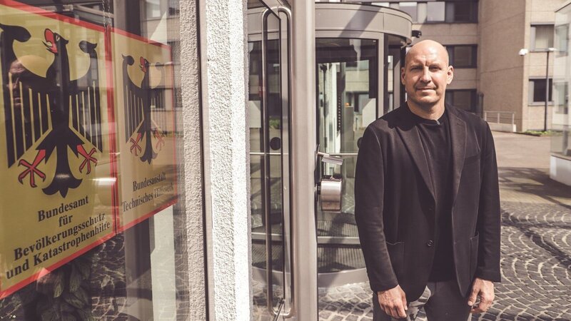 Reporter Sebastian Galle vor dem Bundesamt für Bevölkerungsschutz und Katastrophenhilfe in Bonn. – Bild: Lars Schwellnus