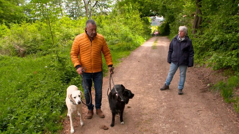 Coach Andreas Ohligschläger (r) zusammen mit Hundehalterin Kerstin und ihren beiden Hunden Maya und Otto (cremefarbener Labrador) – Bild: WDR/​Fernsehkraft UG