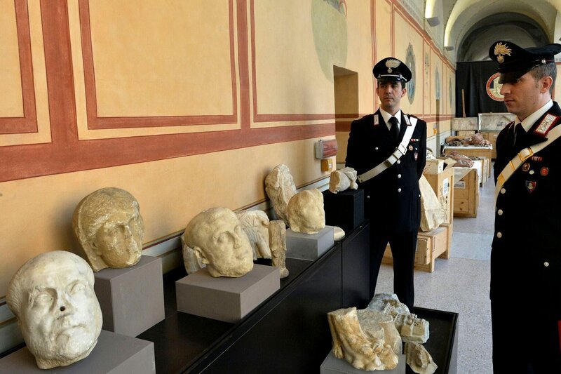 Carabinieri stehen neben geborgenen archäologischen Artefakten in Rom. – Bild: ALBERTO PIZZOLI /​ AFP via Getty Images /​ AFP