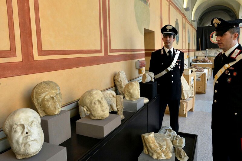 Carabinieri stehen neben geborgenen archäologischen Artefakten in Rom. – Bild: ALBERTO PIZZOLI /​ AFP via Getty Images /​ AFP