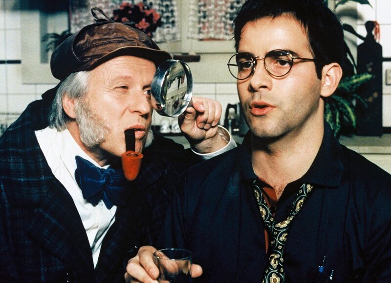 Hans Meier (Walter Andreas Müller, l.), der für den Theaterverein gerade die Rolle des Sherlock Holmes einstudiert, glaubt, Indizien dafür gefunden zu haben, dass mit Bruno Caduff (Beat Marti) offenbar etwas nicht in Ordnung ist. – Bild: SF
