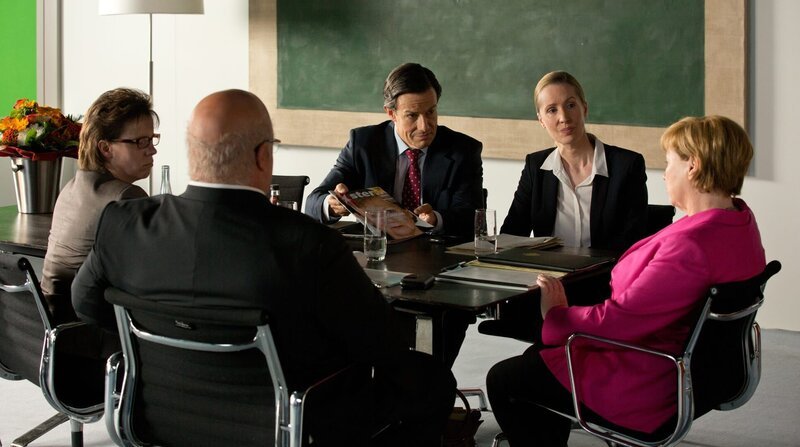 Steffen Seibert (Urs Remond) zeigt Merkel (Imogen Kogge) das Foto der „Eiskönigin“. – Bild: rbb/​carte blanche/​Volker Roloff