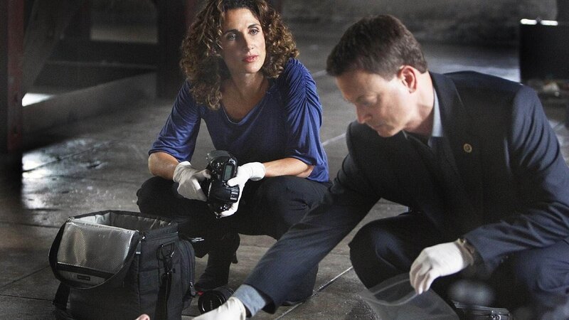 Der Nachtwächter Dario Gonzales (Paul Lacovara, liegend) wird tot aufgefunden. Finden die beiden Detectives Stella Bonasera (Melina Kanakaredes) und Mac Taylor (Gary Sinise) am Tatort Hinweise auf die Todesursache? – Bild: TVNOW /​ CBS