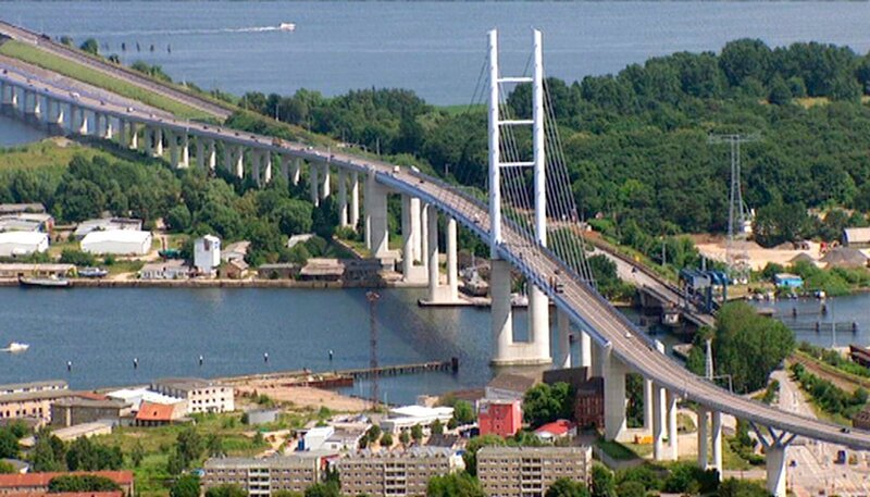 In Mecklenburg-Vorpommern ist der Himmel weiter als sonst. Das sieht man von der Erde aus am besten. Um zu zeigen, wie schön das nordöstlichste Bundesland tatsächlich ist, ist ein Filmteam des NDR in die Luft gegangen. Atemberaubende Bilder von Orten, die man zu kennen glaubt. – Rügenbrücke – Bild: rbb/​NDR