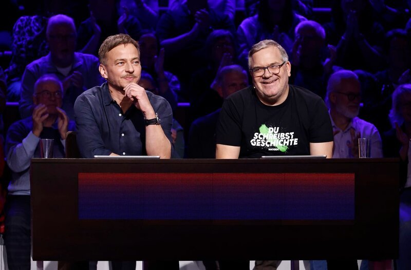 Rateteam-Kapitän Elton (r.) mit Schauspieler Tom Wlaschiha (l.). – Bild: ARD/​Morris Mac Matzen