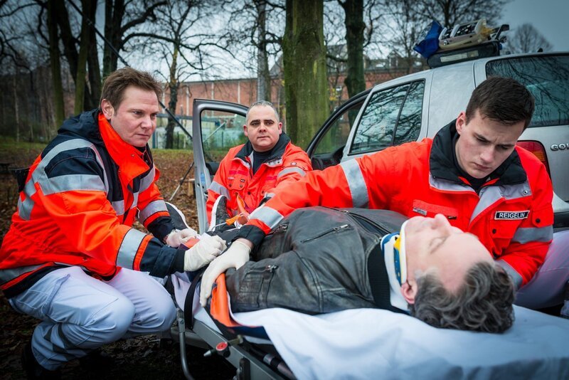 Dr. Haase (Fabian Harloff, l.) und seine Kollegen (Komparsen) kümmern sich um den verletzten Fahrer (Dirk Borchardt, M.) des Unfallwagens. – Bild: ZDF