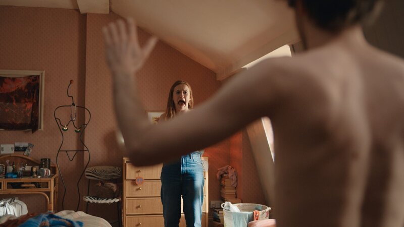 Als Jen (Máiréad Tyers) dabei ist, freizügige Selfies zu machen, wird sie plötzlich von einem nackten Mann (Luke Rollason) in ihrem Zimmer überrascht. – Bild: The Walt Disney Company Limited