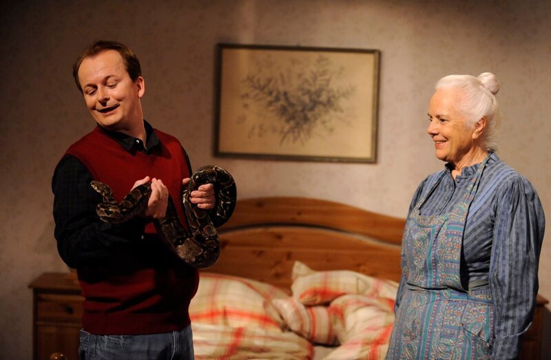 Herr Zillich beruhigt seine Boa Constrictor „Gisela“. Von links: Herr Zillich (Rüdiger Bach) und Theresa Brunner (Ursula Erber). – Bild: Marco Orlando Pichler /​ BR