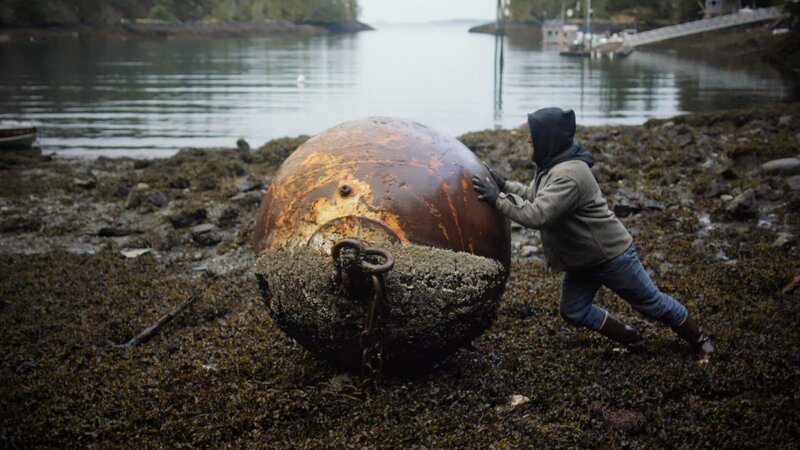 Matt schiebt eine massive Boje in Richtung Ozean. – Bild: National Geographic