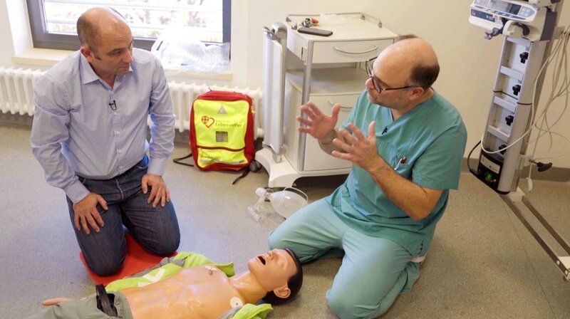 Reporter Patrick Hünerfeld lässt sich von Prof. Michael Müller (re.) einweisen in die Technik der Reanimation. Für den Film war er als „First Responder“ (Ersthelfer) im Einsatz. – Bild: SWR