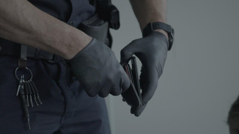 Ein CBP-Beamter überprüft die Brieftasche eines Passagiers auf Anzeichen von Bargeldschmuggel. (National Geographic) – Bild: National Geographic /​ National Geographic