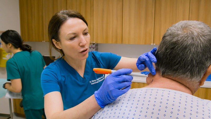 Dr Emma marking the area of Bill’s Lipoma in Clinic. Bill sitting on clinic bed, facing away from camera. Nurse Rosie in background …No.. – Bild: 2022, Discovery, Inc. All Rights Reserved.