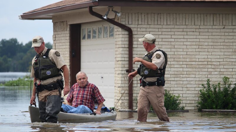 Chris and Benny rescue a man from his flooded home. – Bild: Discovery Communications