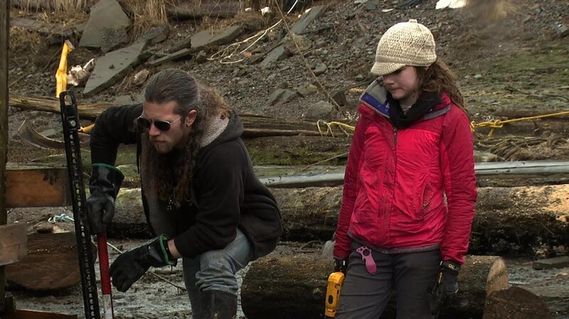Bam Brown with a jack next to the cabin while Rain Brown looks over. – Bild: Discovery Communications