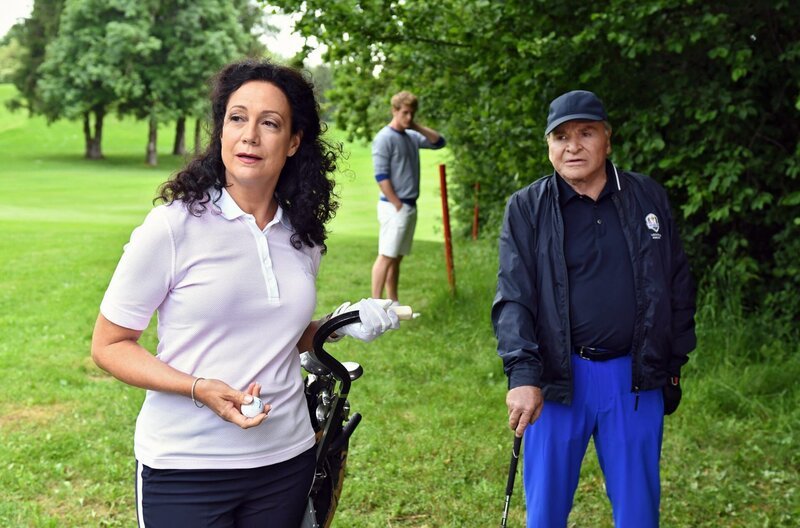 Die Immobilienmaklerin Jenny Winter (Barbara Wussow, l.) versucht sich beim Golfen wieder bei Wöller (Fritz Wepper, r.) einzuschmeicheln. Im HG Wöllers Referent Alex Rauscher (Jakob Geßner), – Bild: ARD/​Barbara Bauriedl /​ ARD-Programmdirektion
