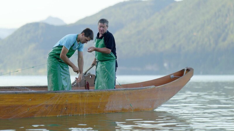 Zwei Personen, die auf einem Schiff im Mondsee segeln – Bild: Bergblick
