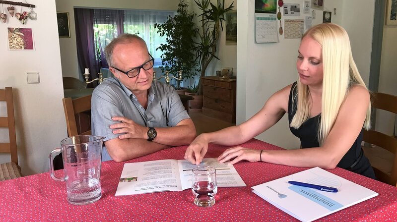 Gereon Niekamp bekommt Besuch von Immobilienmaklerin Rebecca Teich. Sie erklärt ihm, wie er mit der Immobilienrente schon zu Lebzeiten Geld verdienen kann, ohne aus seinem Haus ausziehen zu müssen. – Bild: SWR