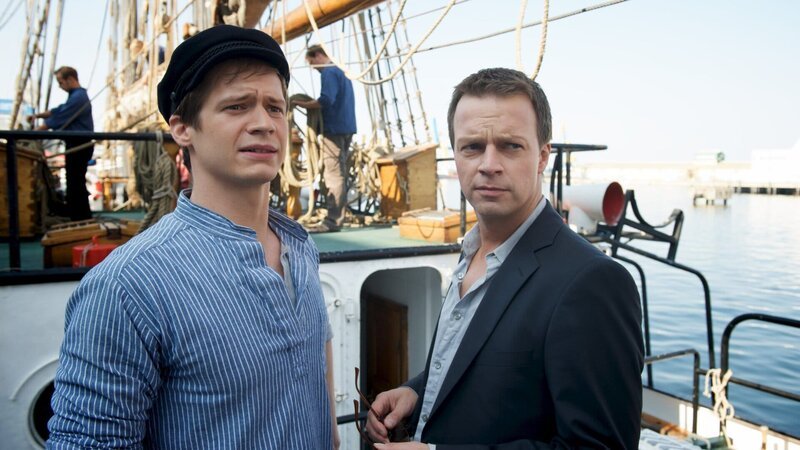 Jano Nissen (Noah Matheis, l.) ist Skipper auf einem Schiff. Der Freund von Bea Kahlow hofft aber schon lange darauf, eines Tages selbst Schiffseigner zu werden. Sven Herzog (Michael Härle, r.) unterhält sich mit ihm. – Bild: ZDF und Marc Meyerbroeker