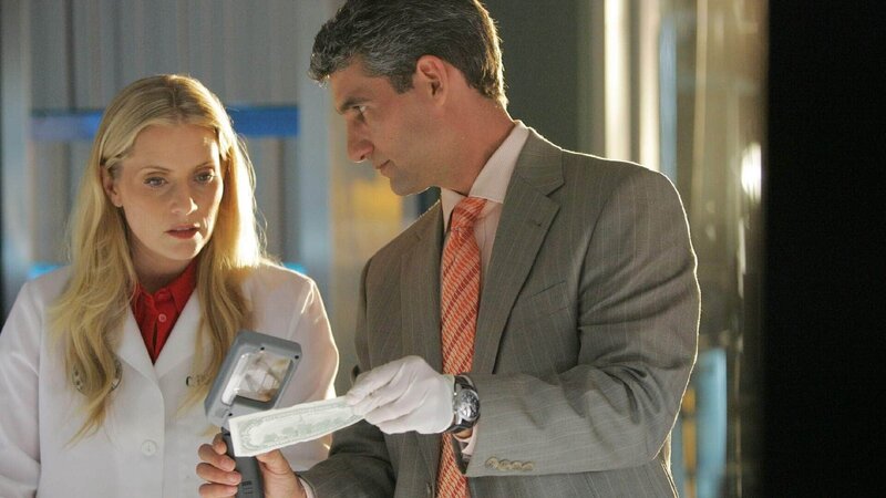 Der Banknoten-Experte Peter Elliott (Michael B. Silver), der schon des öfteren mit Calleigh (Emily Procter) zusammengearbeitet hat, erkennt an Farbe und Bildern, dass das Geld der ermordeten Vargas’ älter als 16 Jahre sein muss, und offensichtlich in einem feuchten Keller aufbewahrt wurden. – Bild: SUPER RTL