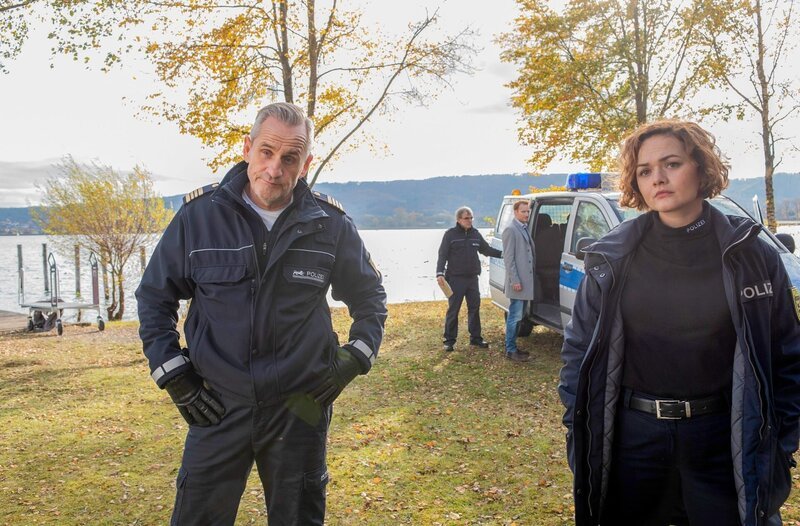 Paul Schott (Tim Wilde, l.) und Julia Demmler (Wendy Güntensperger, r.) müssen verhindern, dass aus einem inszenierten Mord ein richtiger Mord wird (mit Maximilian Dirr, h.r. und Komparse, h.l.). – Bild: ORF/​Bavaria/​ARD/​SWR/​Laurent Trümper